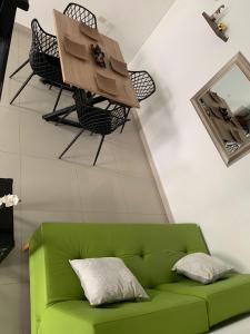 - un canapé vert et une table dans la chambre dans l'établissement CIC Apartamento amoblado Mirador del Sinú, à Montería
