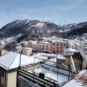 a city with snow covered buildings and a mountain at Casa alla Costa in Mormanno