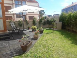 patio z parasolem i doniczkami w obiekcie Apartamento con jardín w mieście Lira