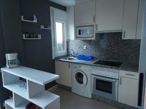 una cucina con lavatrice e lavandino di Apartamento con jardín a Lira