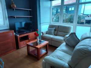 sala de estar con sofá y TV en Apartamento con jardín, en Lira