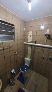 baño con aseo y puerta de cristal en Quartos no centro de Salvador, en Salvador