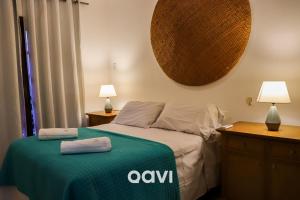 um quarto com uma cama com um cobertor verde e 2 candeeiros em Qavi - Triplex Resort Pipa #Resort19 em Pipa