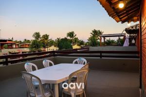 uma mesa branca e cadeiras numa varanda em Qavi - Triplex Resort Pipa #Resort19 em Pipa