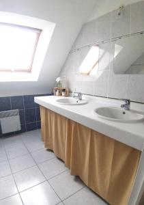 une salle de bain avec deux lavabos et un grand miroir dans l'établissement Maison confort Trégomeur avec jardin et parking, à Trégomeur