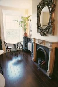 a living room with a fireplace and a mirror at Number 8 The Townhouse in Derry Londonderry