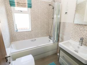 a bathroom with a tub and a toilet and a sink at Serendipity - Heritage Park in Narberth +24 photos