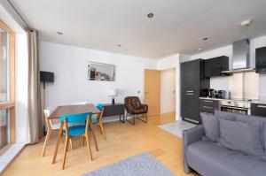 a kitchen and a living room with a table and chairs at D8 - Canal View Apartment in London