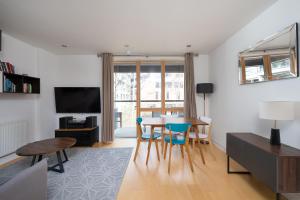 a living room with a table and chairs and a television at D8 - Canal View Apartment in London