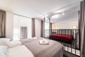 a hotel room with a bed with towels on it at Owl Jazz Apartments - luxury apartments in the heart of the city in Kaunas