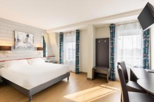 a bedroom with a bed and a desk and a computer at Best Western Hotel & SPA Pau Lescar Aeroport in Lescar