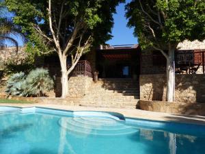 Agadir-Taghazout Magnifique Villa Dar Lina 4 etoiles في أغادير: مسبح امام بيت اشجار