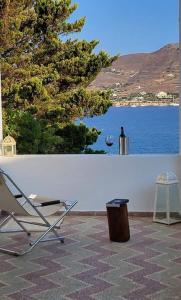 a chair sitting on a patio with a view of the water at Alegria in Posidhonía