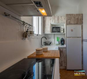 cocina con nevera blanca y encimera de madera en Apartamento Peñón Blanco, en La Isleta del Moro