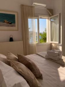 a bedroom with a large bed with a window at Alegria in Posidhonía