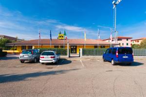 tres autos estacionados en un estacionamiento frente a un edificio en Hotel Campana, en Reggio Emilia