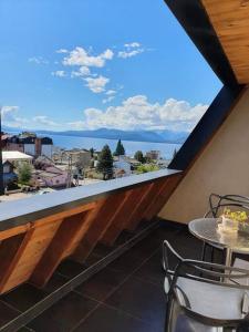 balcón con mesa y vistas a la ciudad en Lenga De Fuego Apartamentos Deluxe Bariloche en San Carlos de Bariloche