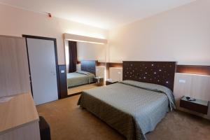 Habitación de hotel con cama y espejo en Hotel Campana, en Reggio Emilia