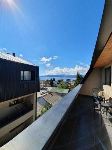 - Balcón de un edificio con mesa y sillas en Lenga De Fuego Apartamentos Deluxe Bariloche en San Carlos de Bariloche