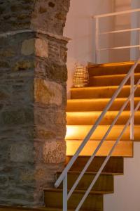 un conjunto de escaleras con una pared de piedra en Grammata Suites, en Ermoupoli