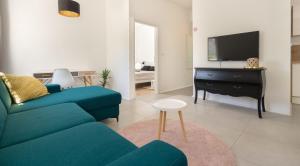 a living room with a blue couch and a tv at Apartman LIS in Pomer