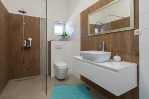 a bathroom with a sink and a toilet and a shower at Apartman LIS in Pomer +15 photos