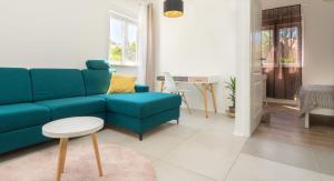 a living room with a blue couch and a table at Apartman LIS in Pomer
