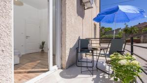 a patio with a table and an umbrella at Apartman LIS in Pomer