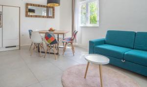 a living room with a blue couch and a table at Apartman LIS in Pomer