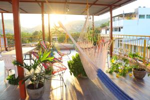 a balcony with plants and a hammock on a building at Hotel Casa Mandarine , Amazing Private Rooms w Balcony, Rooftop, Hammocks, AC, SmarTV, 100mbs! in Zihuatanejo