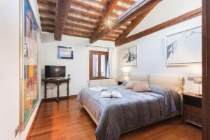 a bedroom with a large bed and a television at San Marco Luxury Loft with Terrace in Venice