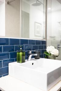 W łazience znajduje się biała umywalka i niebieskie kafelki. w obiekcie BB Casamatta w mieście Napoli