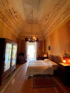 um quarto com uma cama e um lustre em Palazzo Sabella Tommasi em Calimera