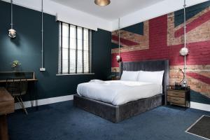 a bedroom with a bed and a brick wall at The Quarters in Weedon Bec