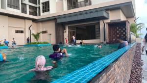 un groupe de personnes dans l'eau d'une piscine dans l'établissement Js homestay, à Malacca
