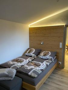 Schlafzimmer mit einem Bett mit einem Kopfteil aus Holz in der Unterkunft Römer Appartement mit sonniger Terrasse in Bad Reichenhall