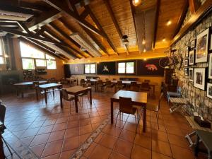 un restaurante con mesas y sillas en una habitación en Albergue Cueva de Valporquero, en Vegacervera