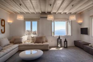 ein Wohnzimmer mit Sofa und Tisch in der Unterkunft Newly built spectacular Sunset villa at St. John, Mykonos in Mykonos Stadt