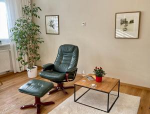 a living room with a chair and a table at Leipzig-Apartments nahe Bahnhof, BMW und UFZ, inkl Parkplatz und Fahrräder in Leipzig