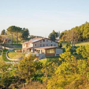 una gran casa blanca en una colina con árboles en Aura Relais en Urbino