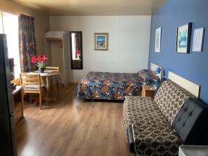 um quarto com uma cama, uma mesa e um sofá em Motel Rayalco em Laurier Station