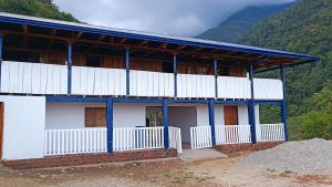 budynek z niebieskim dachem i górami w tle w obiekcie Finca El Encanto del Guejar w mieście Lejanías
