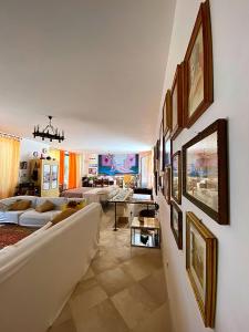 カリメーラにあるPalazzo Sabella Tommasiのソファ付きのリビングルーム、壁に絵画が飾られています。