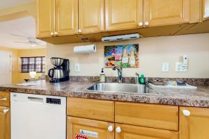 a kitchen with a stainless steel sink and wooden cabinets at Southernmost Retreat in Key West