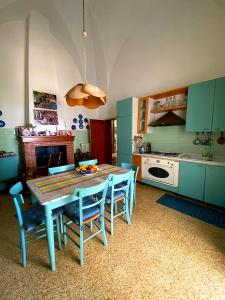 uma cozinha com uma mesa e alguns armários azuis em Palazzo Sabella Tommasi em Calimera
