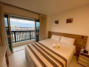 a bedroom with a bed and a large window at Flat Hotel Vision Hplus frente para Esplanada - SEM CAFÉ - Acomodação Particular in Brasilia