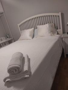a bed with white sheets and towels on it at Apartamento Zaragoza Plaza Europa in Zaragoza