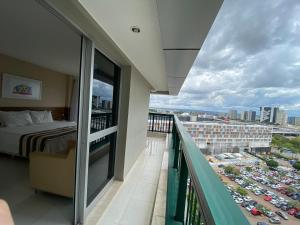 a balcony with a bed and a view of a city at Flat Hotel Vision Hplus frente para Esplanada - SEM CAFÉ - Acomodação Particular in Brasilia