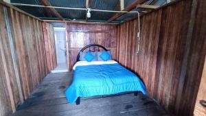 a bed in the inside of a wooden room at Finca El Encanto del Guejar in Lejanías
