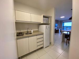 a kitchen with a sink and a refrigerator at Flat Hotel Vision Hplus frente para Esplanada - SEM CAFÉ - Acomodação Particular in Brasilia